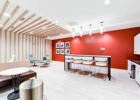 resident lounge with social seating, tables, and catering kitchen at archer park apartments in southeast Washington dc