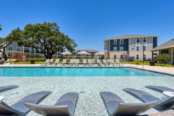 our apartments have a resort style pool with lounge chairs at Estraya Boerne, Boerne