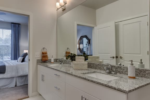 a bathroom with white cabinets and granite counter top and a mirror at Estraya Boerne, Texas, 78006