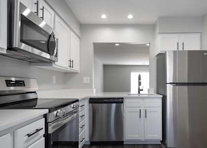 A modern kitchen with stainless steel appliances and white cabinets.