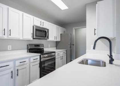 A kitchen with white cabinets and appliances.