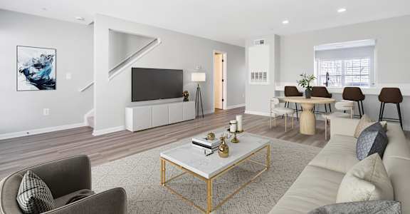 A living room with a grey couch, a coffee table, and a painting on the wall.