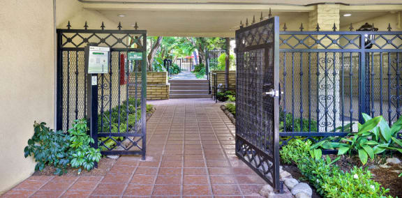 the entrance to a building with a gate and a courtyard  at Casa De Oro Apartments, California