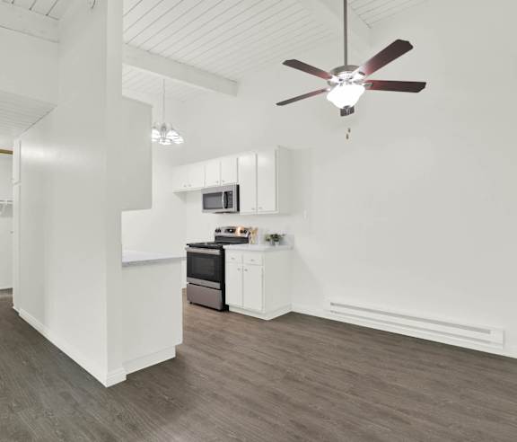 an open kitchen and living room with white walls and wood floors at Willow Tree Apartments, Torrance, CA, 90505