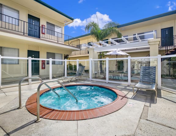 a jacuzzi in the middle of a pool in front of a building at Olive Tree Apartments, Torrance, 90503