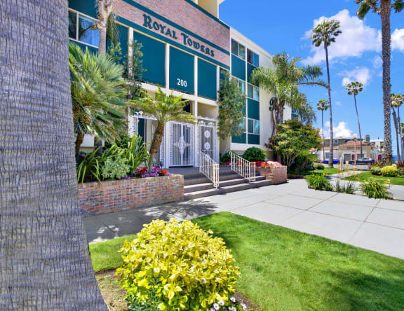 a woman riding a wave on a surfboard in the ocean at Royal Towers Apartments, Redondo Beach, 90277