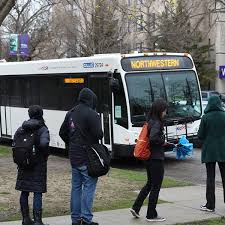 A white bus with the words "Northwestern" on the top is parked on the side of a road.