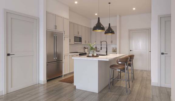 A modern kitchen with a white island and stainless steel appliances.at Elysium, Phoenix, AZ