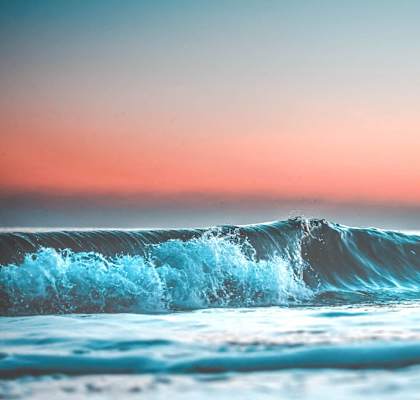 a wave in the ocean with a sunset in the background t Camino de Oro Apartments, Torrance, CA, 90505