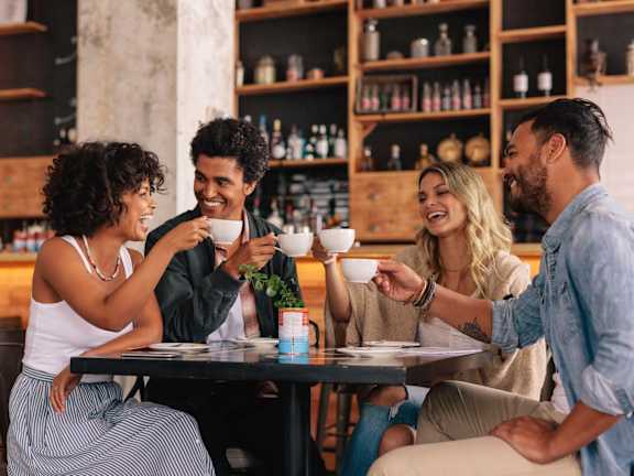 A group of people toasting with wine glasses at a dinner table.