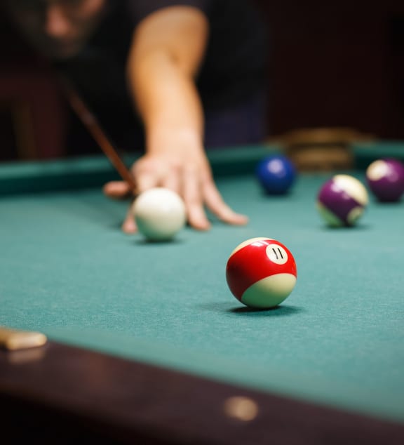 a person playing pool on a pool table  at The Hub, Lacey, WA
