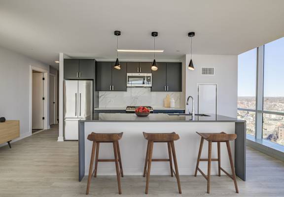 Modern kitchen interior with sleek countertops, stainless steel appliances, and ample natural light