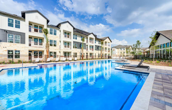 a swimming pool with an apartment building in the background at Legacy at Cibolo, Boerne, TX, 78006