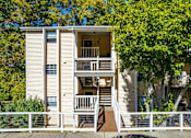 Thumbnail 28 of 28 - a white apartment building with stairs and trees at Landmark at Lyncrest Reserve Apartments, Nashville, TN