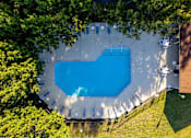 Thumbnail 22 of 28 - An aerial view of a swimming pool surrounded by trees at Landmark at Lyncrest Reserve Apartments, Nashville, TN
