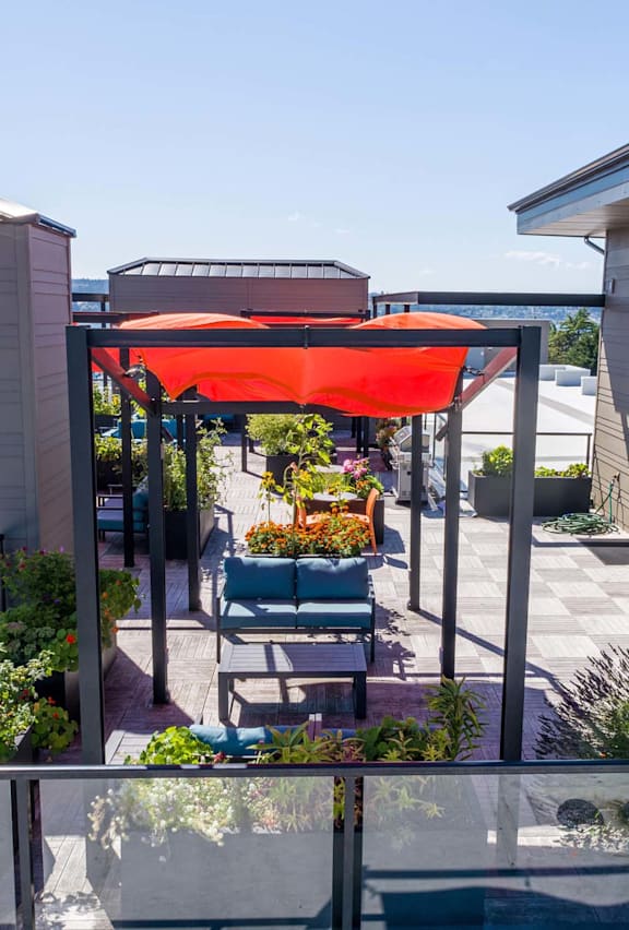 A patio with a table and chairs under a red awning.