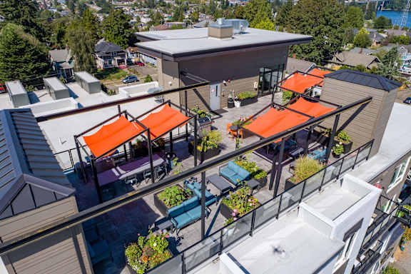 A patio with orange awnings and a glass railing.