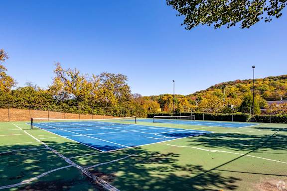 two tennis courts with trees in the background on a sunny day at Landmark at Lyncrest Reserve Apartments, Nashville, TN