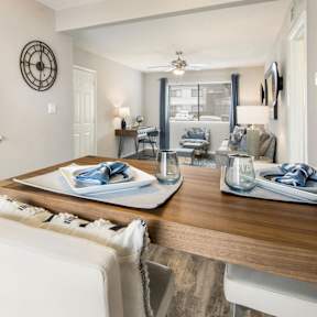 a dining room and living room with a wooden table and white chairs