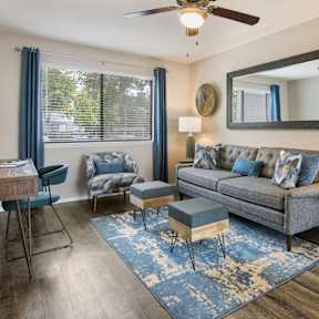 a living room with a couch and chairs and a window