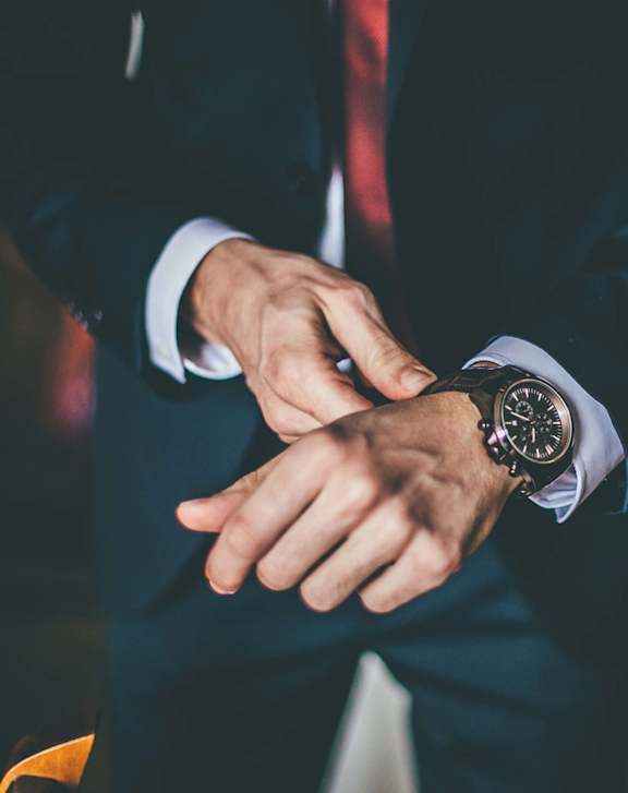 A man in a suit is checking the time at Burbank Gardens Apartments, Sherman Oaks, California
