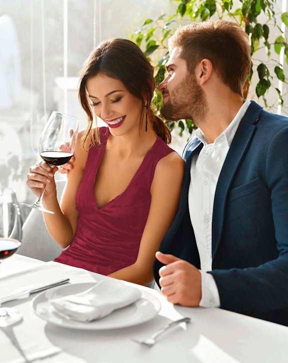 A man and a woman are eating food at an outdoor restaurant.at Pacific Bay Club Apartments, California
