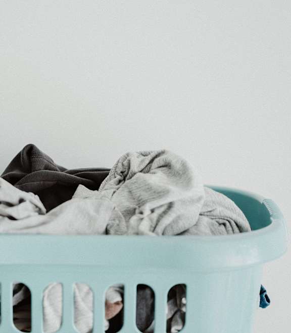 a blue laundry basket filled with folded clothes