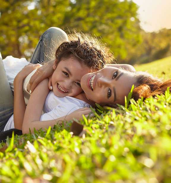 Woman lying on grass with daughter at White Oak Gardens, Encino, CA, 91316