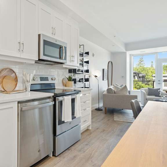 A modern kitchen with white cabinets and stainless steel appliances.