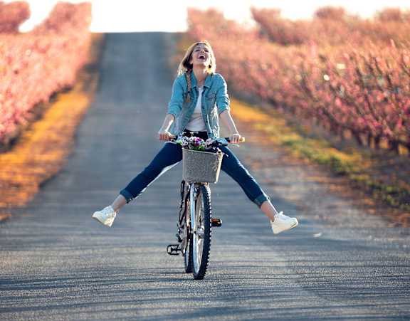 A woman is riding a bicycle on a road at Stillwater Lakes Apartments, Florida
