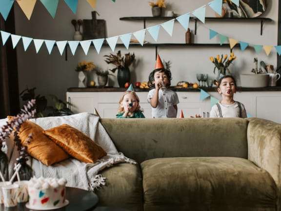 a group of children standing around a couch at a birthday party