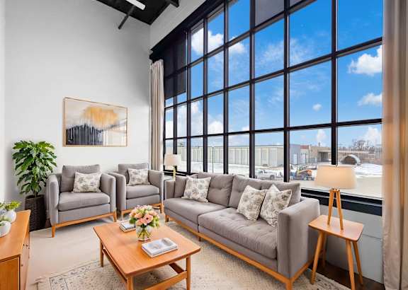 A living room with a large window and a view of the city.at Plant 1 Lofts, Iowa, 50208