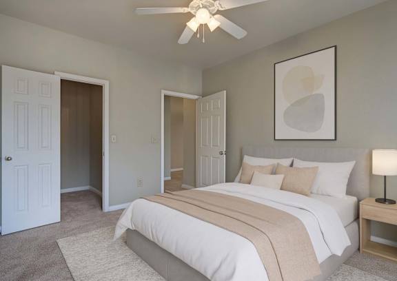A bedroom with a large bed and a ceiling fan.