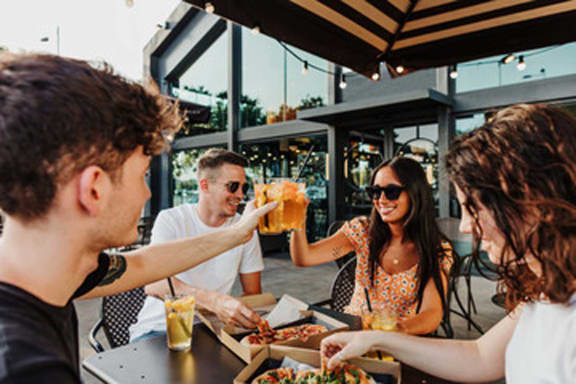 a group of people sitting around a table eating food