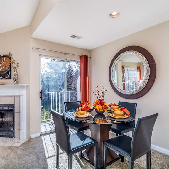 A dining room with a fireplace and a table set for a meal.