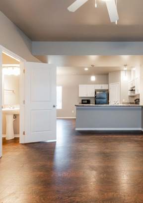 A spacious kitchen and living room with hardwood floors and a ceiling fan. at Danamere Village, Iowa, 50047