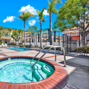 a jacuzzi pool with palm trees and a building in the background at Camino de Oro Apartments, Torrance, CA, 90505
