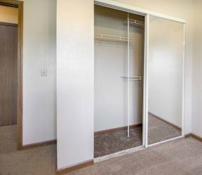 A room with a white wall and a brown carpet at Hunters Run Apartments, IA, 50208