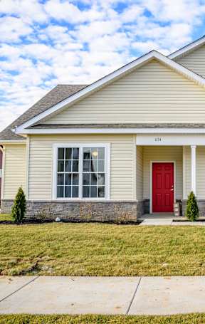 A house with a red door and a grey facade.