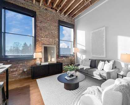 A living room with a brick wall and a fireplace.at Plant 1 Lofts, Iowa, 50208