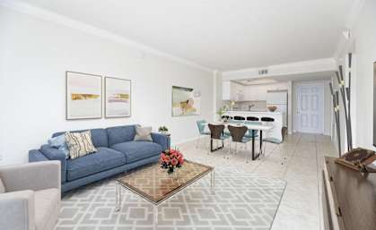 a living room and dining room with a blue couch and a table