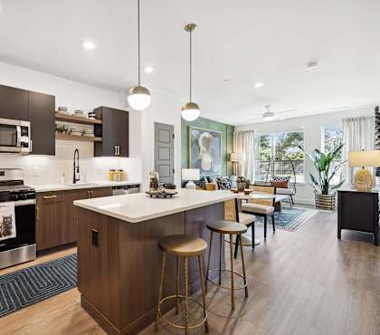 A modern kitchen with dark wood cabinets and a white island.