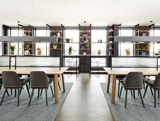 A modern dining room with a long table and chairs.