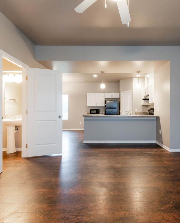 A spacious kitchen and living room with hardwood floors and a ceiling fan. at Danamere Village, Iowa, 50047
