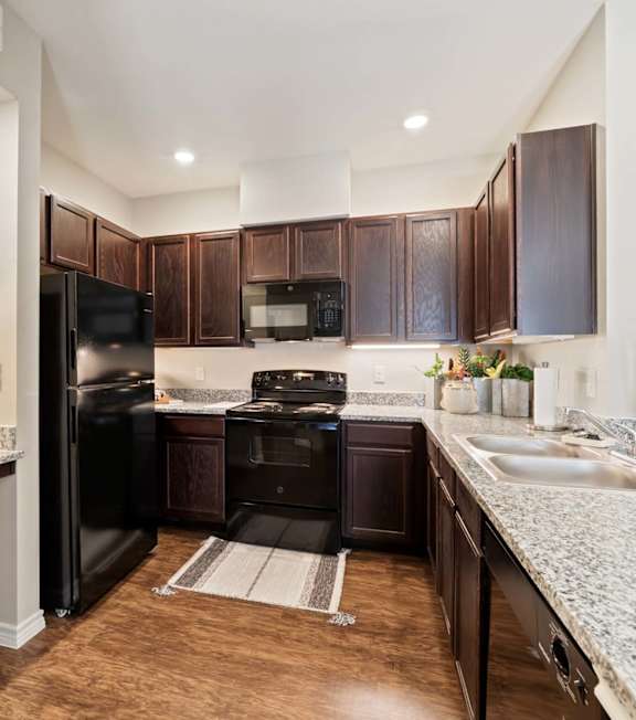 A kitchen with a black counter top and stove. at Residences at the Landing, Kerrville, TX, 78028