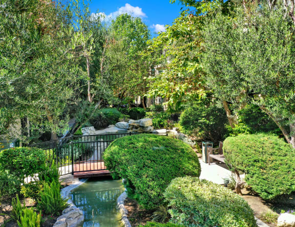 a bridge over a pond in a garden  at Willow Tree Apartments, California
