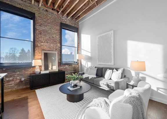 A living room with a brick wall and a fireplace.at Plant 1 Lofts, Iowa