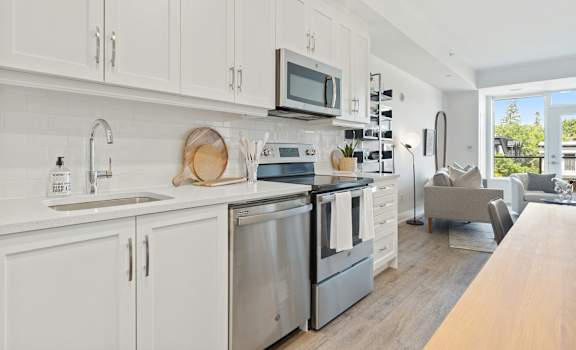 A modern kitchen with white cabinets and stainless steel appliances.