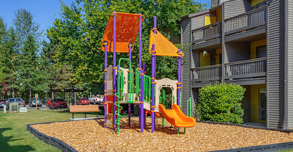 A playground with a slide, swings, and a climbing frame.