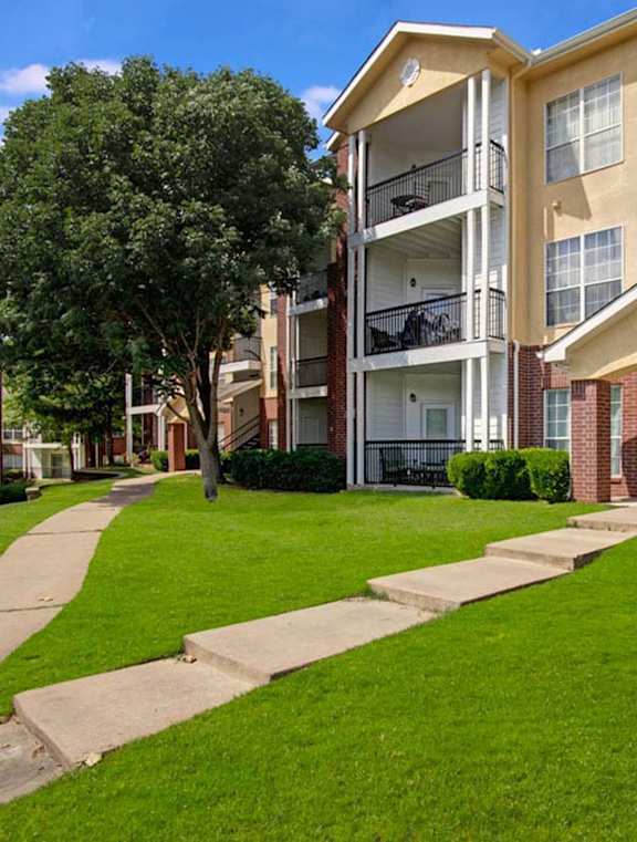 Apartment complex with a green lawn in front.